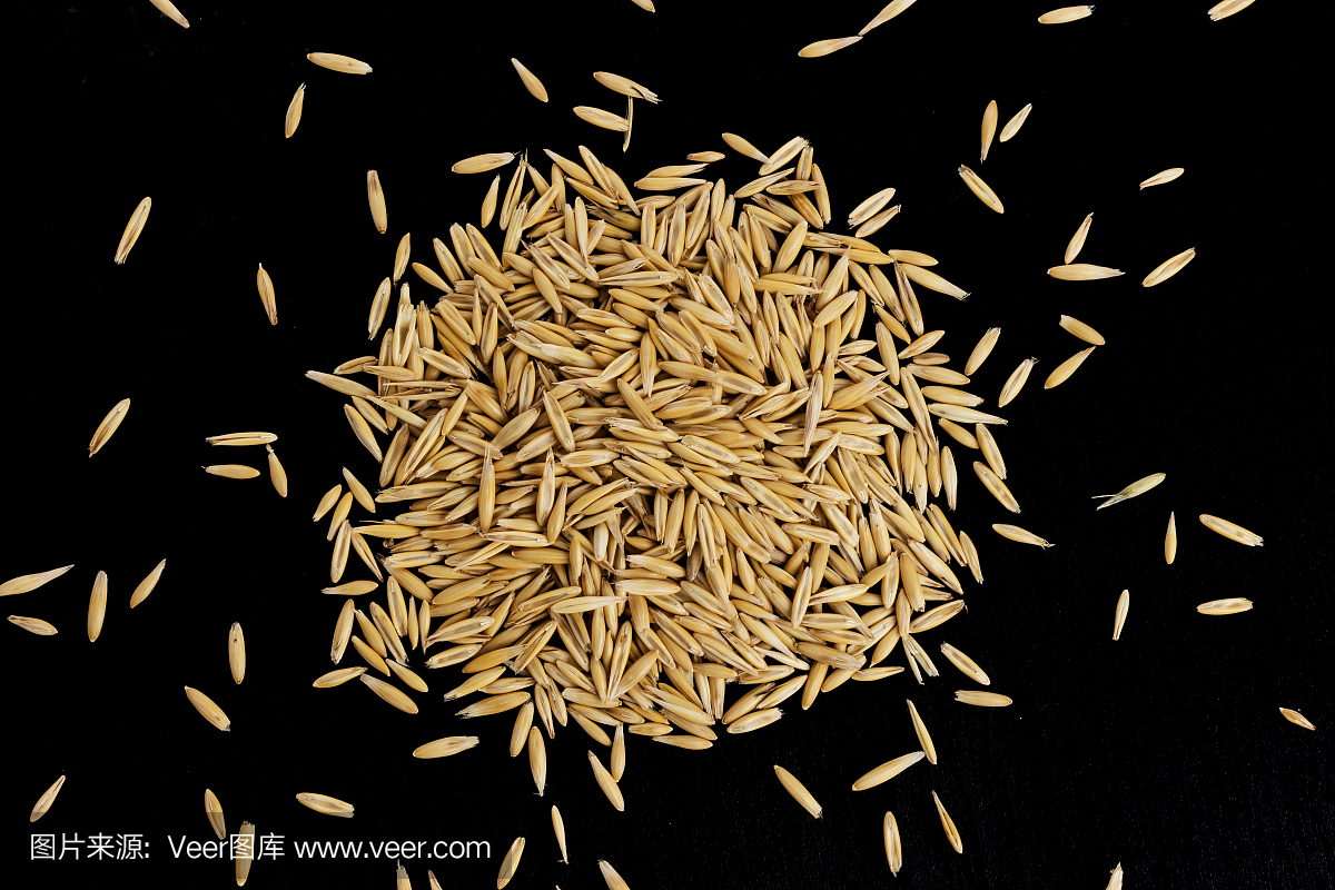 燕麦种子堆在黑色背景,俯视图